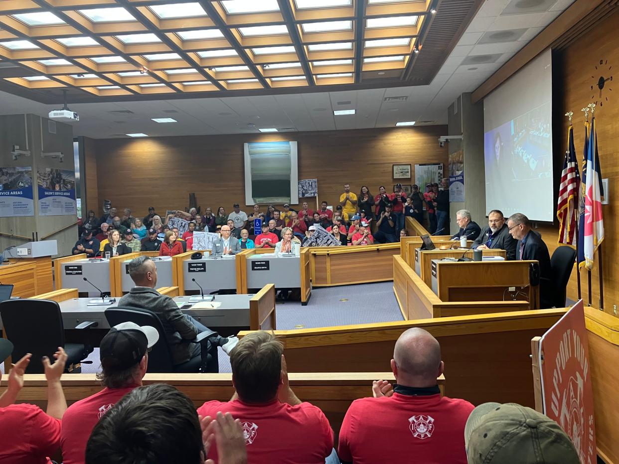 Local firefighters protesting the city's decision to challenge giving line-of-duty benefits to a Salem firefighter's widow break out in applause after city leaders announce their decision to drop their challenge to the courts.
