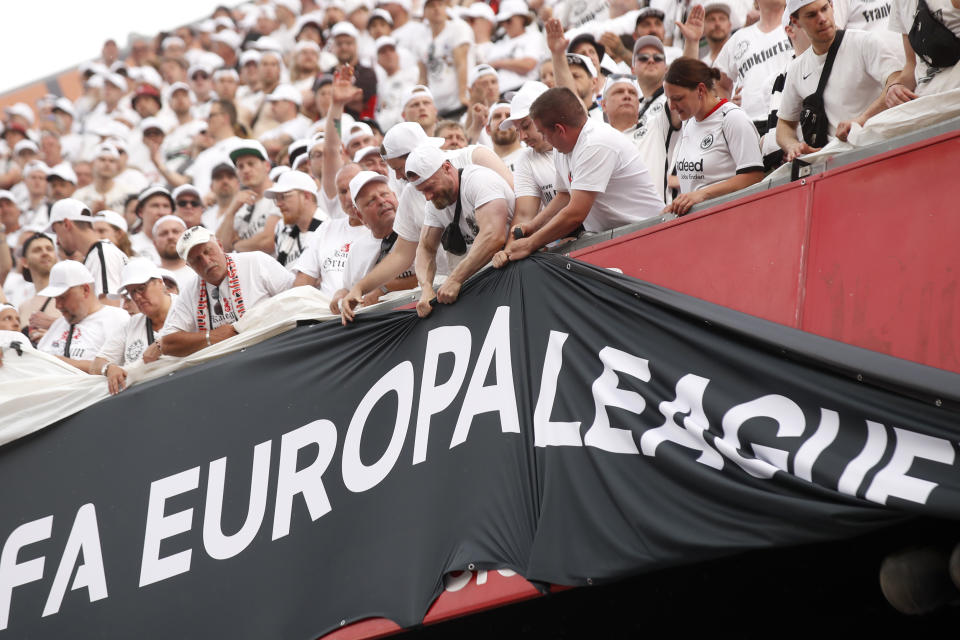 Fans try to move a banner before the Europa League final soccer match between Eintracht Frankfurt and Rangers FC at the Ramon Sanchez Pizjuan stadium in Seville, Spain, Wednesday, May 18, 2022. (AP Photo/Pablo Garcia)