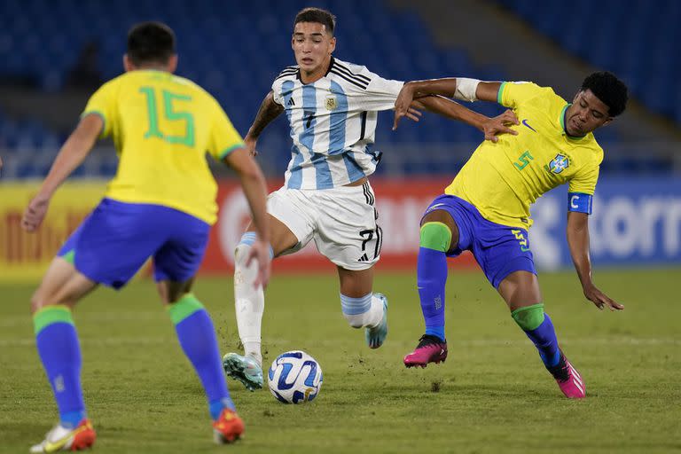 Julián Fernández desplaza a Andrey Santos mientras otro rival lo espera de frente