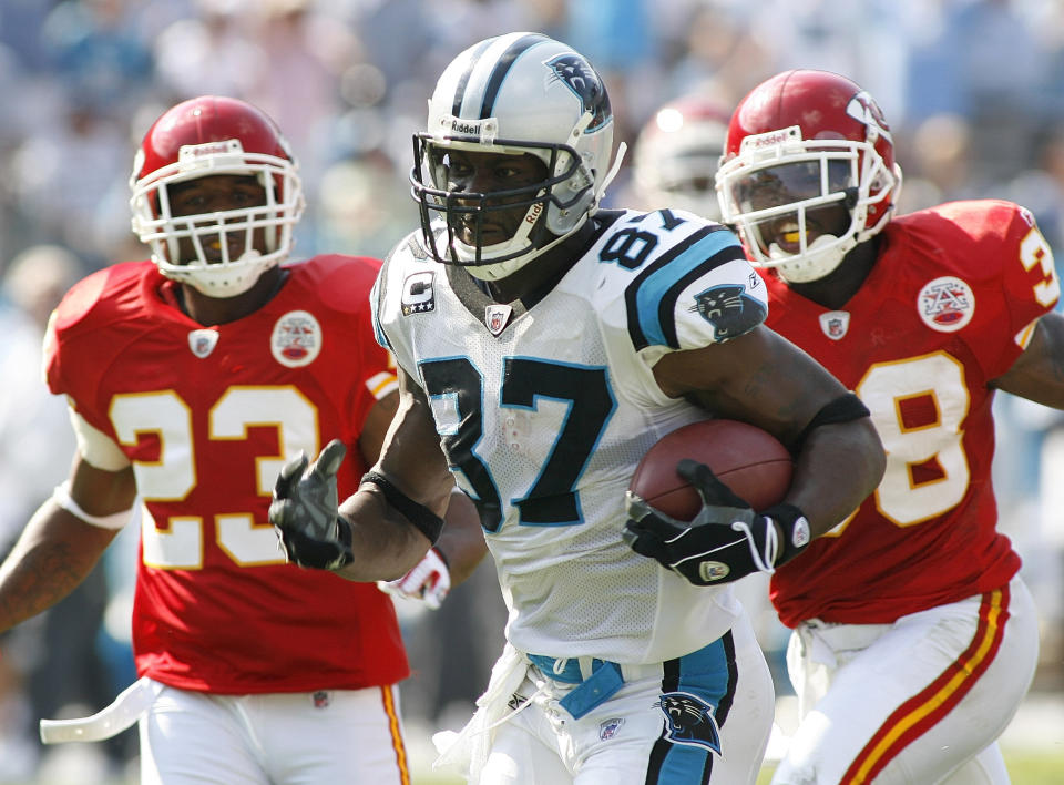 FILE - Carolina Panthers' receiver Muhsin Muhammad (87) races for a touchdown while being chased by Kansas City Chiefs' Patrick Surtain (23) and DaJuan Morgan (38) in the second half of an NFL football game Sunday, Oct. 5, 2008, in Charlotte, N.C. The Carolina Panthers announced they're inducting defensive end Julius Peppers and wide receiver Muhsin Muhammad into the team’s Hall of Honor. The inductions will take place at Bank of America Stadium at halftime of the team’s Oct. 29 game against the Houston Texans. (AP Photo/Rick Havner, File)