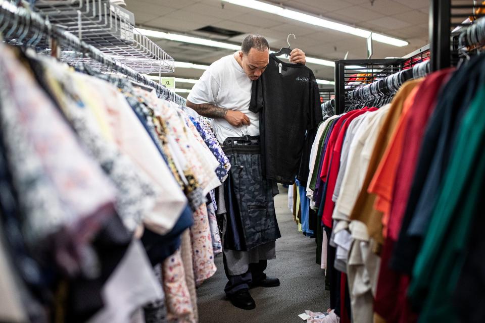 Ronnell Johnson tries on new clothes at the K&G Fashion Superstore in Dearborn before heading to a restaurant in Livonia to surprise his daughter on Wednesday, June 1, 2022.