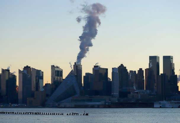 PHOTO: An emission comes out of a smokestack on the west side of Manhattan as the sun rises in New York City on Jan. 16, 2022, as seen from Weehawken, New Jersey. (Gary Hershorn/Getty Images)