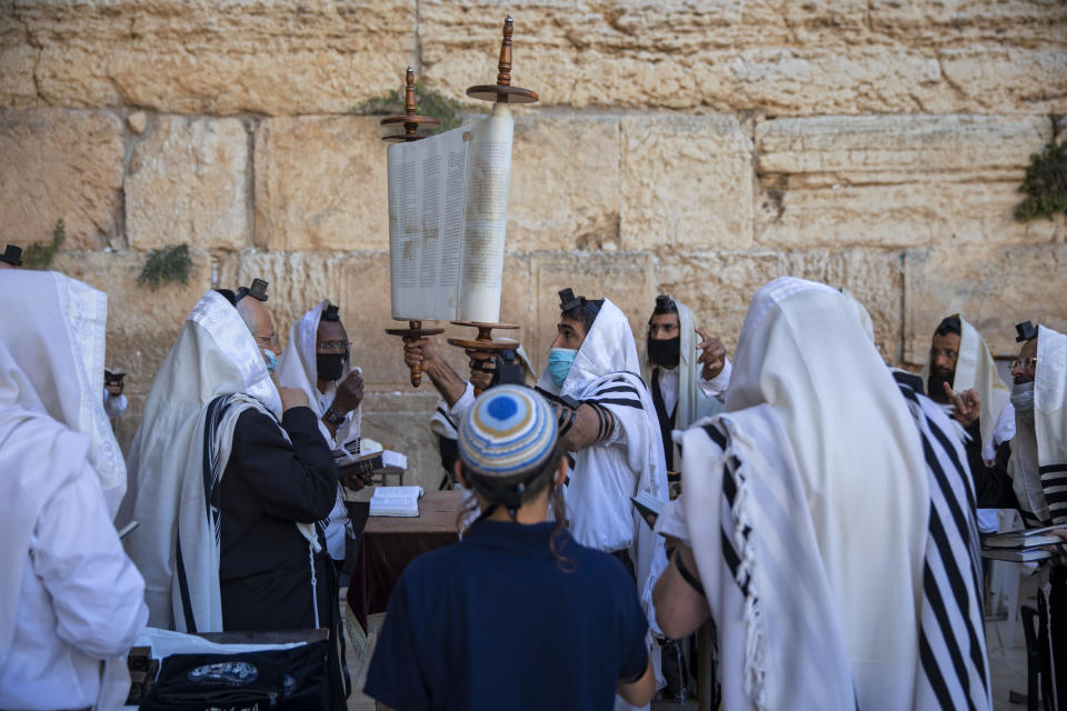 Ultra-Orthodox Jewish men wear protective mace masks during morning prayer at the Western Wall, the holiest site where Jews can pray, in Jerusalem's Old City, Thursday, July 16, 2020. The Western Wall plaza is divided to sections which allowed maximum twenty people following the government's measures to help stop the spread of the coronavirus. (AP Photo/Oded Balilty)