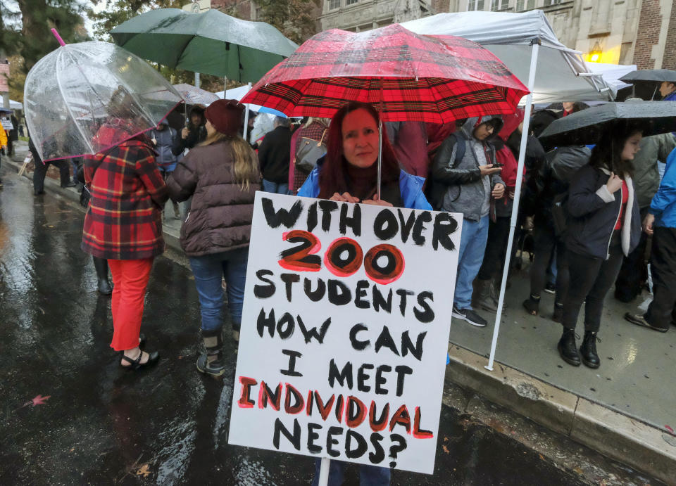 FILE - In this Jan. 14, 2019 file photo, teachers strike in the rain outside John Marshall High School in Los Angeles. Teachers who declared a victory after a six-day strike have added momentum to a wave of activism by educators. They've tapped a common theme and found success by framing their cause as a push to improve public education, not just get pay raises. (AP Photo/Ringo H.W. Chiu, File)