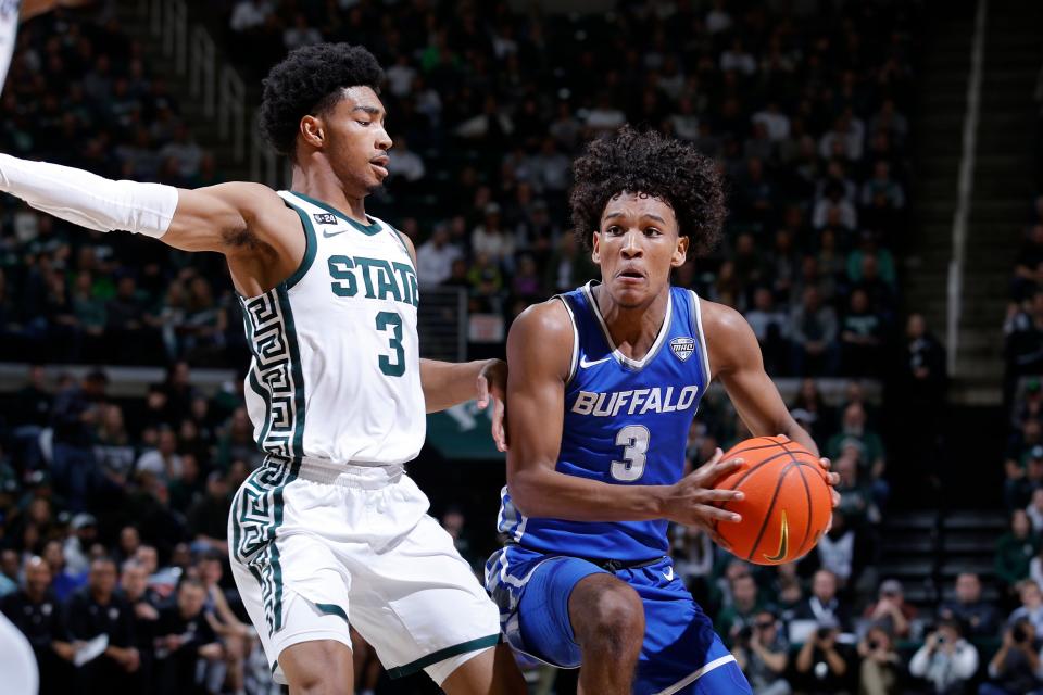 Buffalo's Curtis Jones, right, drives against Michigan State's Jaden Akins during the first half of an NCAA college basketball game Friday, Dec. 30, 2022, in East Lansing, Mich.