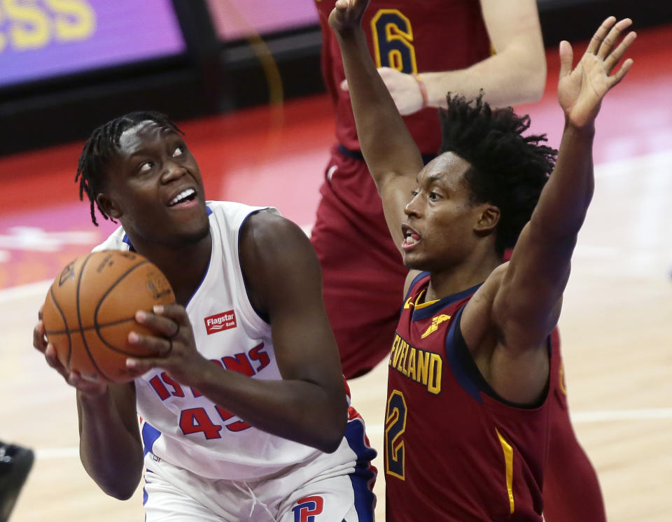 Detroit Pistons forward Sekou Doumbouya, left, is guarded by Cleveland Cavaliers guard Collin Sexton, right, during the first half of an NBA basketball game Saturday, Dec. 26, 2020, in Detroit. (AP Photo/Duane Burleson)