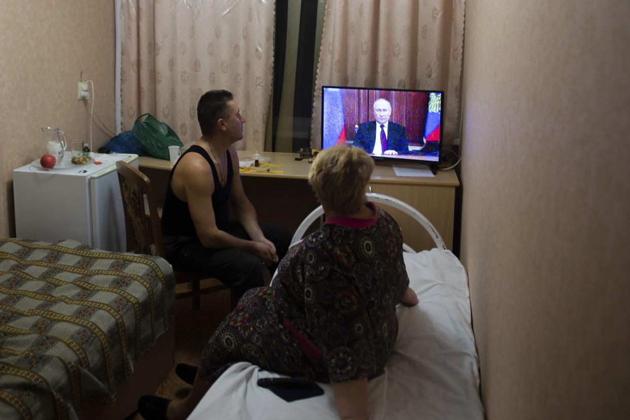 People from the Donetsk and Luhansk regions, the territory controlled by pro-Russia separatist governments in eastern Ukraine, watch Russian President Vladimir Putin's address at their temporary place in Rostov-on-Don region, Russia, Monday, Feb. 21, 2022. Putin said he would decide later Monday whether to recognize the independence of separatist regions in eastern Ukraine, a move that would ratchet up tensions with the West amid fears that Moscow could launch an invasion of Ukraine imminently.