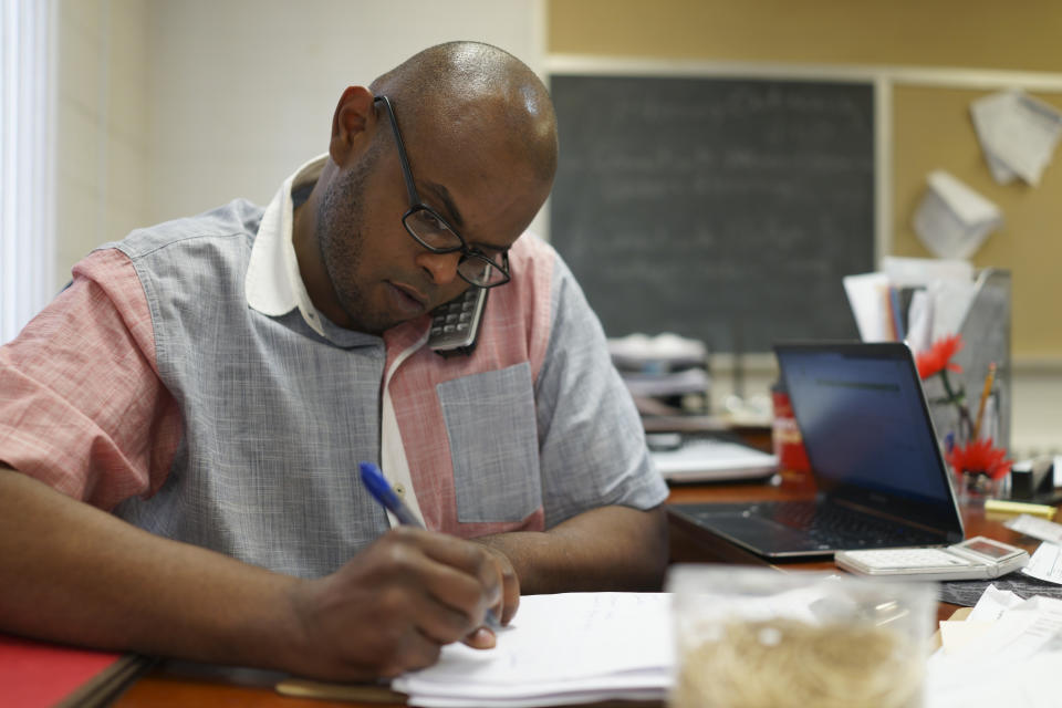 Warsame Guled, a navigator with the Somali Health Solutions office, helps a client on the phone with their health care enrollment while he waited for the MNsure website to process another client's enrollment, Monday, March 31, 2014, in Minneapolis. The call center for Minnesota's online health insurance marketplace strained Monday under a crush of people trying to beat the midnight Monday deadline for open enrollment, while residents lined up to take advantage of locations offering in-person help. (AP Photo/Star Tribune, Jeff Wheeler)