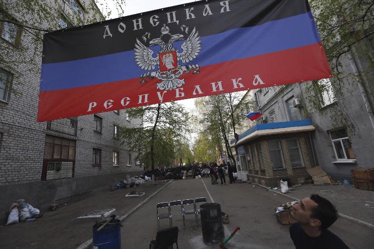 A man looks at a flag of a self-proclaimed Donetsk republic in front of a captured police station on April 19, 2014 in Slavyansk, eastern Ukraine