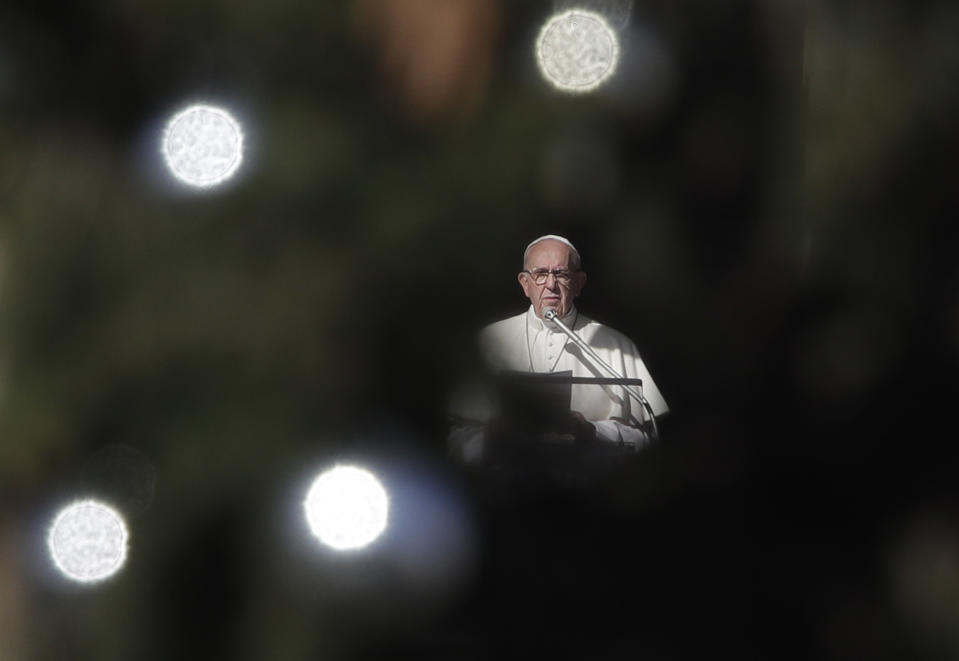 Framed by a Christmas tree, Pope Francis delivers his speech during the Angelus noon prayer he delivered from his studio window overlooking St. Peter's Square at the Vatican, Saturday, Dec. 8, 2018. (AP Photo/Alessandra Tarantino)