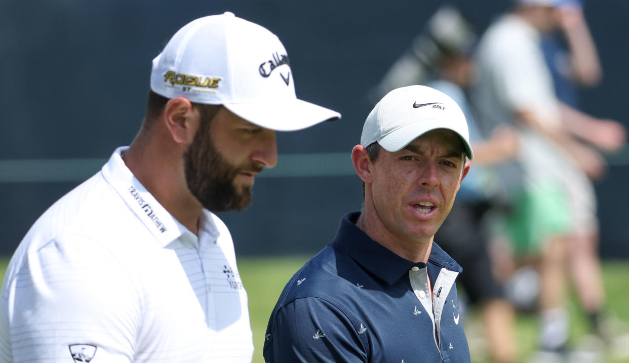  Jon Rahm and Rory McIlroy walk down the fairway 