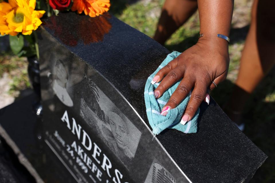 Clover Anderson, of Fort Pierce, cleans her son, Akiefe Jamal Anderson's, headstone, Saturday, Aug. 12, 2023, at Riverview Memorial Park in downtown Fort Pierce. "This is my weekly life," said Anderson. "We keep him clean because that's the person he was, neat and clean and good." Akiefe, 22, was found with a gunshot wound about 2:45 a.m. on Aug. 28, 2021 on Avenue M Extension east of U.S. 1 north in Fort Pierce. St. Lucie County Sheriff's Office has not announced any arrests but said they are trying to find a 2012 silver Ford Focus in connection with the homicide.