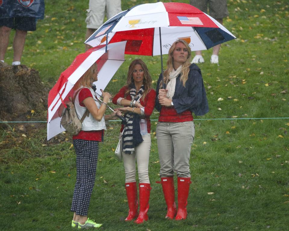 Tiger Woods girlfriend Lindsey Vonn (R) stands under an umbrella with Fred Couples girlfriend Nadine Moze during the Singles matches for the 2013 Presidents Cup golf tournament at Muirfield Village Golf Club in Dublin, Ohio October 6, 2013. REUTERS/Jeff Haynes (UNITED STATES - Tags: SPORT GOLF ENTERTAINMENT)