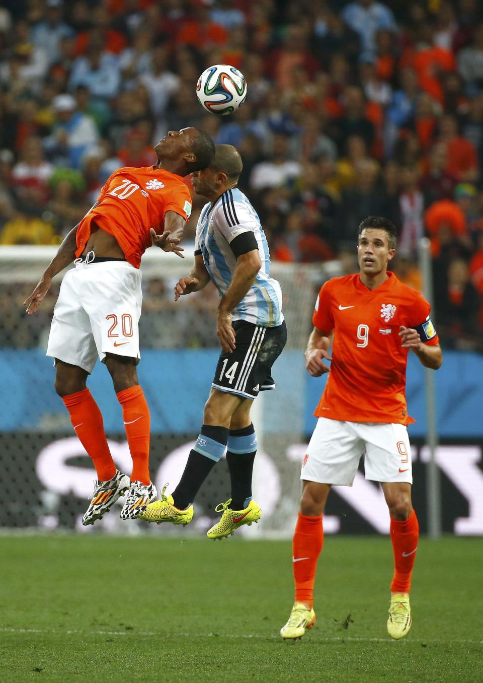 Wijnaldum of the Netherlands and Argentina's Mascherano collide as they jump for the ball during their 2014 World Cup semi-finals at the Corinthians arena in Sao Paulo