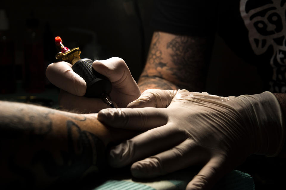 Midsection Of Man Tattooing On Hand