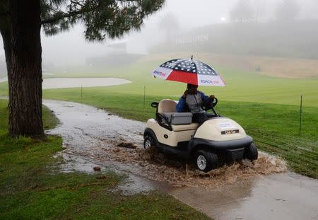 February 14, 2019; Pacific Palisades, CA, USA; A golf cart is driven thru standing water along the second course fairway during a stoppage in play in the first round of the Genesis Open golf tournament at Riviera Country Club. Mandatory Credit: Gary A. Vasquez-USA TODAY Sports