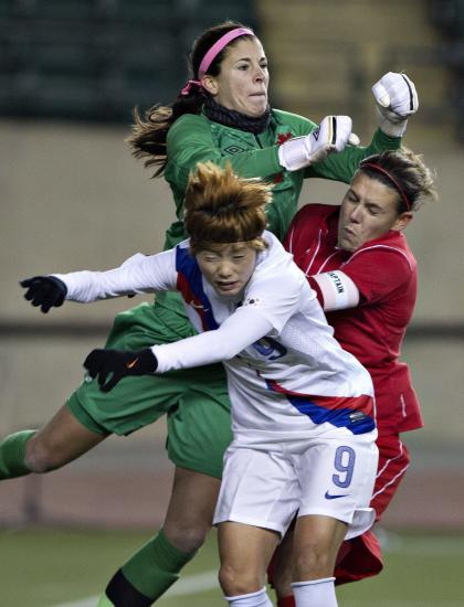 South Korea's Ga Eul Jeon (9) and Canada's Christine Sinclair (12) crash into goal keeper Stephanie Labbe (21) during the second half of an international friendly soccer match, Wednesday, Oct. 30, 2013, in Edmonton, Alberta. (AP Photo/The Canadian Press, Jason Franson)