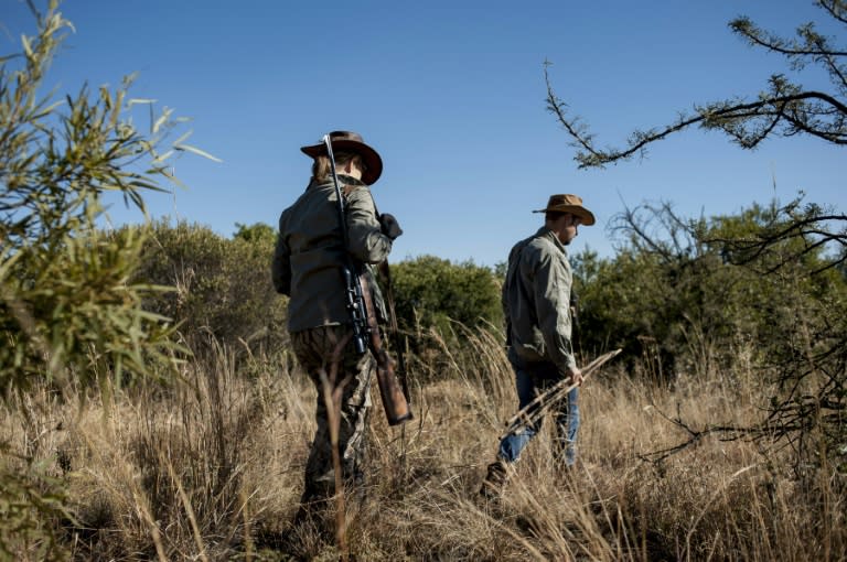 Adri Kitshoff, chief executive officer of Professional Hunters' Association of South Africa (PHASA), and profesional hunter Tavi Fragoso (R) are seen during a hunt at the Iwamanzi Game Reserve in Koster in June 2015