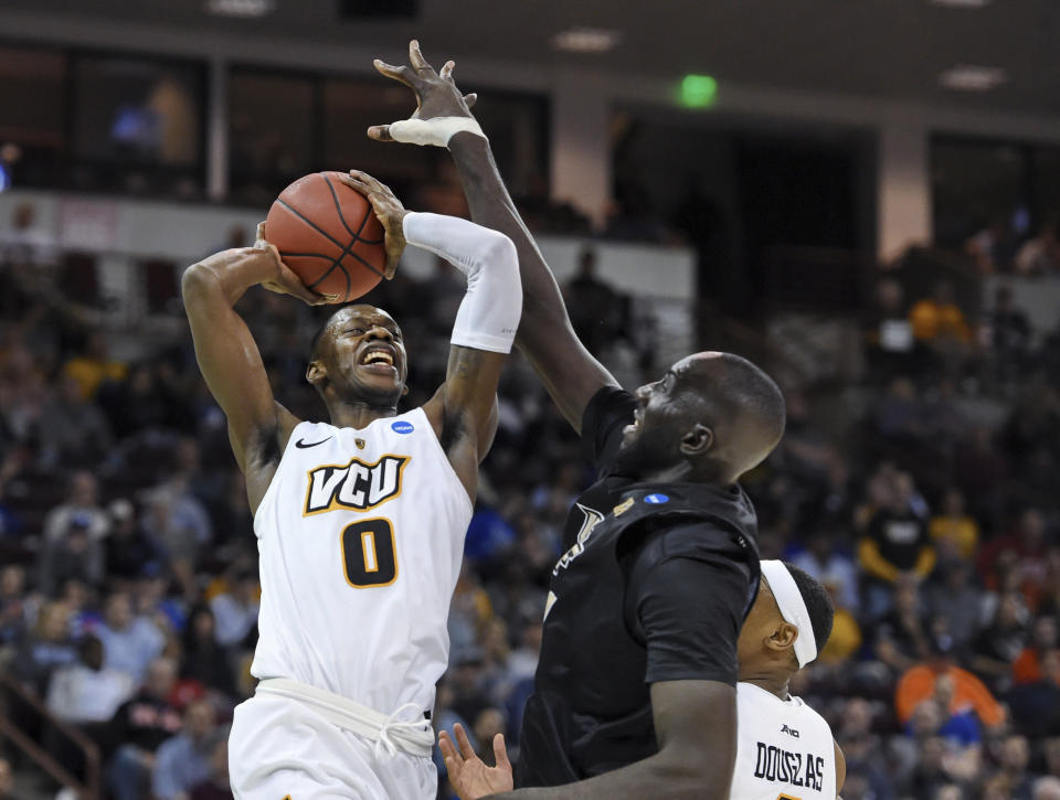 VCU's De'Riante Jenkins (0) is fouled by Central Florida's Tacko Fall, right, during the first half of a first-round game in the NCAA men’s college basketball tournament Friday, March 22, 2019, in Columbia, S.C. (AP Photo/Richard Shiro)