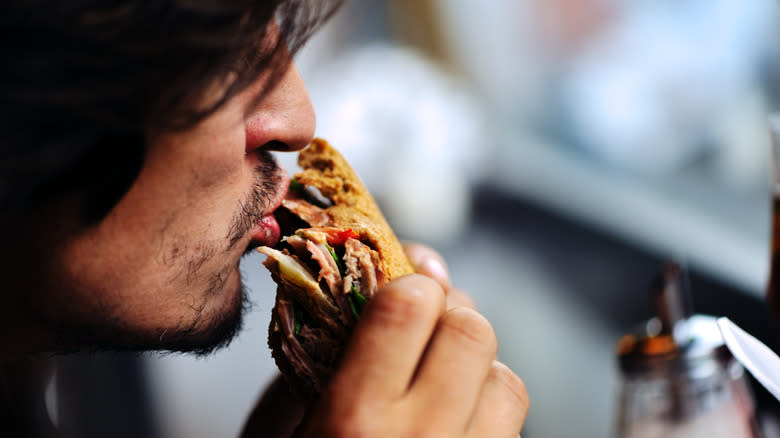 man biting sandwich