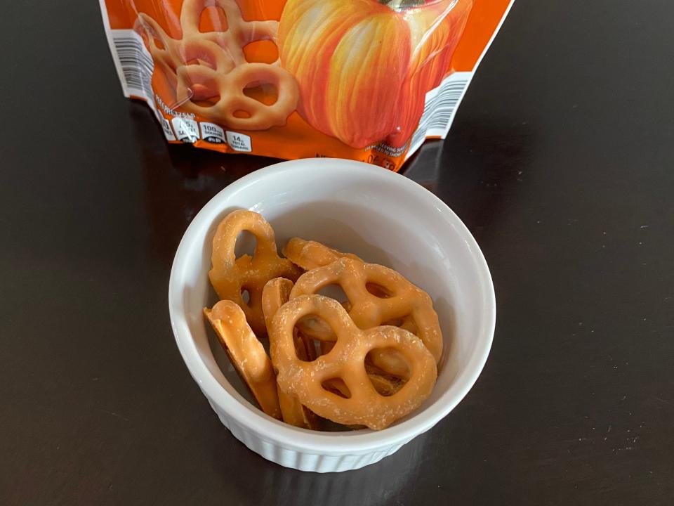 Small white bowl of pumpkin yogurt covered pretzels from aldi