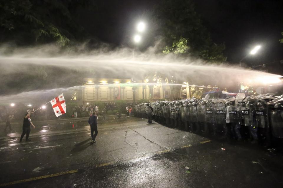 Riot police use a water cannon during an opposition protest against "the Russian law" near the Parliament building in Tbilisi, Georgia, on Wednesday, May 1, 2024. Clashes erupted between police and opposition demonstrators protesting a new bill intended to track foreign influence that the opposition denounced as Russia-inspired. (AP Photo/Zurab Tsertsvadze)