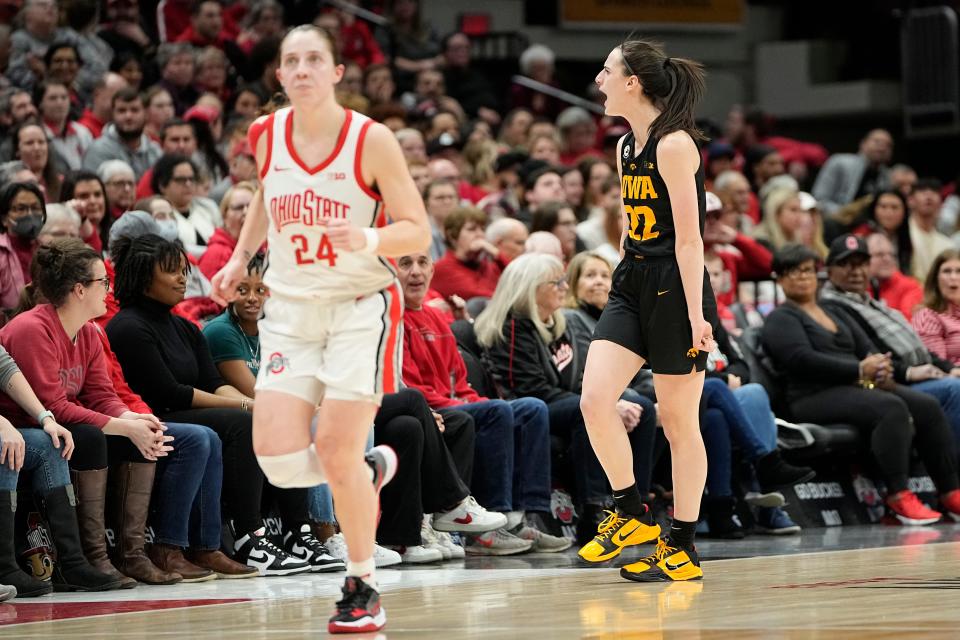 Iowa guard Caitlin Clark (22) celebrates a 3-pointer behind Ohio State's Taylor Mikesell (24) during last year's game between the two teams in Columbus.