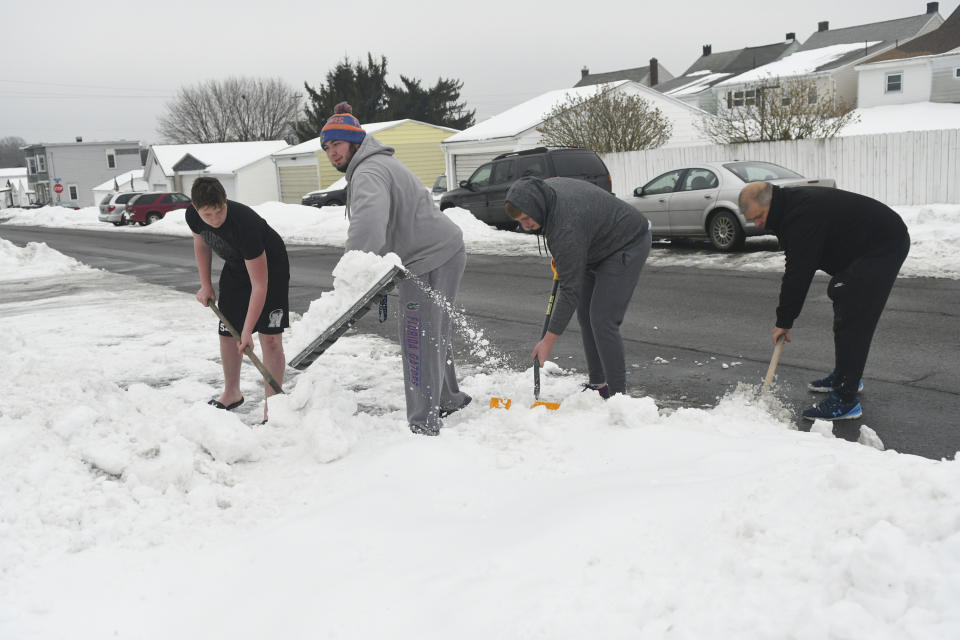 From left, George Shimko III, Devan Shimko, Hunter Shimko, and their father George Shimko Jr., shovel out a parking spot in Frackville, Pa., on Monday, Feb. 15, 2021. (Jacqueline Dormer/Republican-Herald via AP)