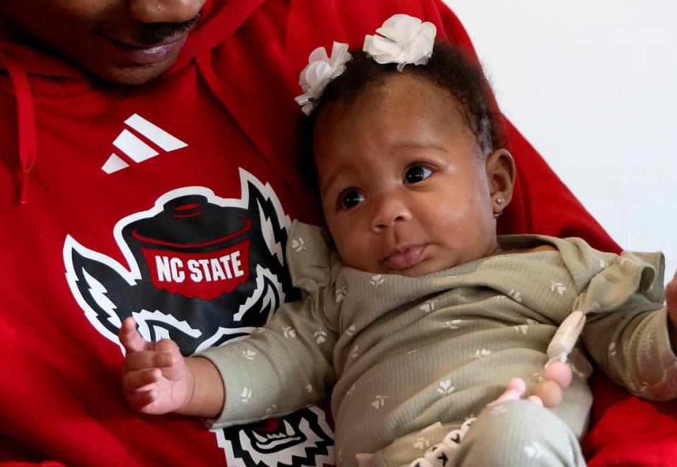 N.C. State’s Rakeim Ashford holds his three-month-old daughter, Ra’Kiya, on Tuesday, Nov. 14, 2023, at the Wendell Murphy Football Center in Raleigh, N.C.