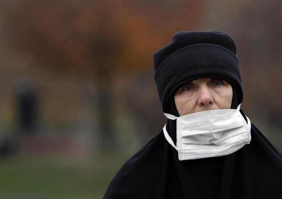 A nun stands in front of St. Sava Temple during the funeral procession of Patriarch Irinej in Belgrade, Serbia, Sunday, Nov. 22, 2020. The 90-year-old Irinej died early on Friday, nearly three weeks after he led the prayers at a funeral of another senior church cleric in neighboring Montenegro, who also died after testing positive for the virus. (AP Photo/Darko Vojinovic)