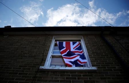 A British flag flutters in front of a window in London, Britain, June 24, 2016 after Britain voted to leave the European Union in the EU BREXIT referendum. REUTERS/Reinhard Krause