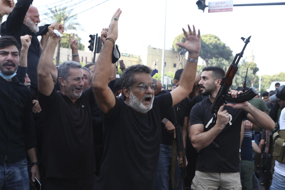 Supporters of the Shiite Hezbollah and Amal groups chant slogans during the funeral processions of Hassan Jamil Nehmeh, who was killed during Thursday clashes, in the southern Beirut suburb of Dahiyeh, Lebanon, Friday, Oct. 15, 2021. Dozens of gunmen opened fire in the air Friday south of Beirut during the funeral of persons killed in hours of gun battles between heavily armed gunmen the day before that left seven people dead and terrorized the residents of Beirut. (AP Photo/Bilal Hussein)