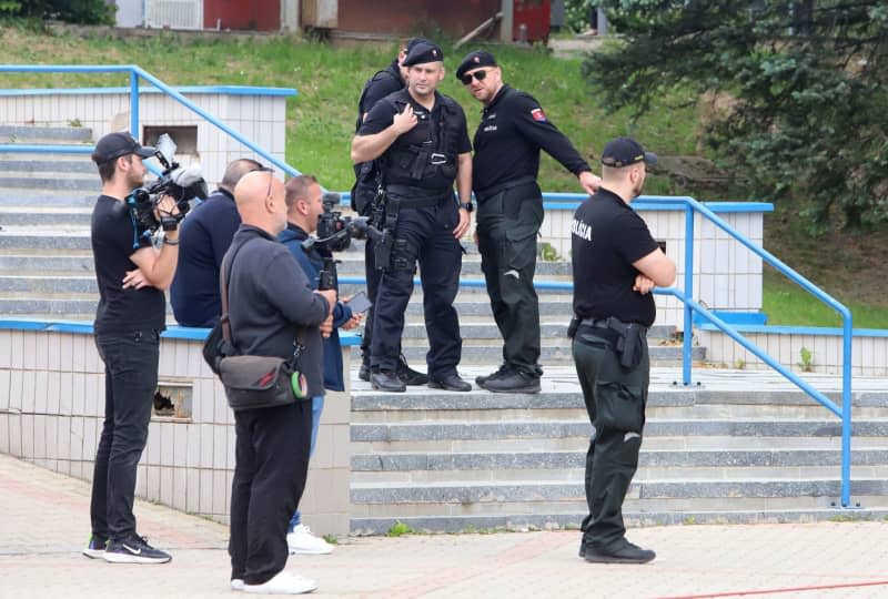 Media representatives and police stand outside the hospital where Slovak Prime Minister Robert Fico remains in intensive care two days after the assassination attempt on his life and it is unclear if he will make a full recovery. Ján Krošlák/TASR/dpa
