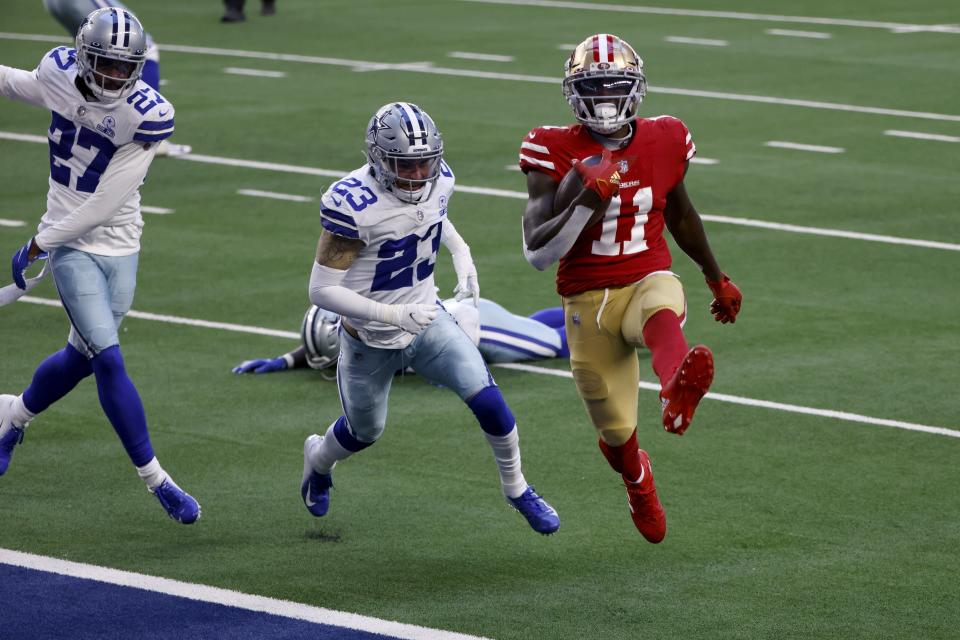 San Francisco 49ers wide receiver Brandon Aiyuk (11) high steps into the end zone after catching a pass for a touchdown in front of Dallas Cowboys' Trevon Diggs (27) and Darian Thompson (23) in the first half of an NFL football game in Arlington, Texas, Sunday, Dec. 20, 2020. (AP Photo/Ron Jenkins)