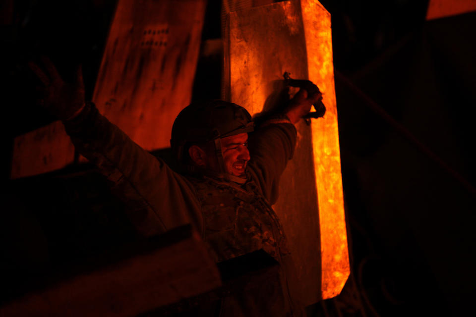 An anti-government protester watches the burning fires at Independence Square in Kiev, Ukraine, Thursday, Feb. 20, 2014. Ukraine's protest leaders and the president they aim to oust called a truce Wednesday, just hours after the military raised fears of a widespread crackdown with a vow to defeat "terrorists" responsible for seizing weapons and burning down buildings. (AP Photo/ Marko Drobnjakovic)