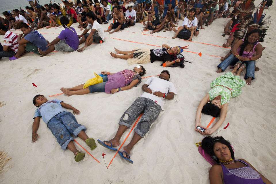 People participate in a human banner on Flamengo beach, organized by Amazon Watch, on the sidelines of the Rio+20, or UN Conference on Sustainable Development in Rio de Janeiro, Brazil, Tuesday, June 19, 2012. The activists are calling attention to threats posed to rivers, forests and livelihoods by large hydroelectric dams, like the Belo Monte hydroelectric plant being constructed in Brazil's Amazon. (AP Photo/Victor R. Caivano)