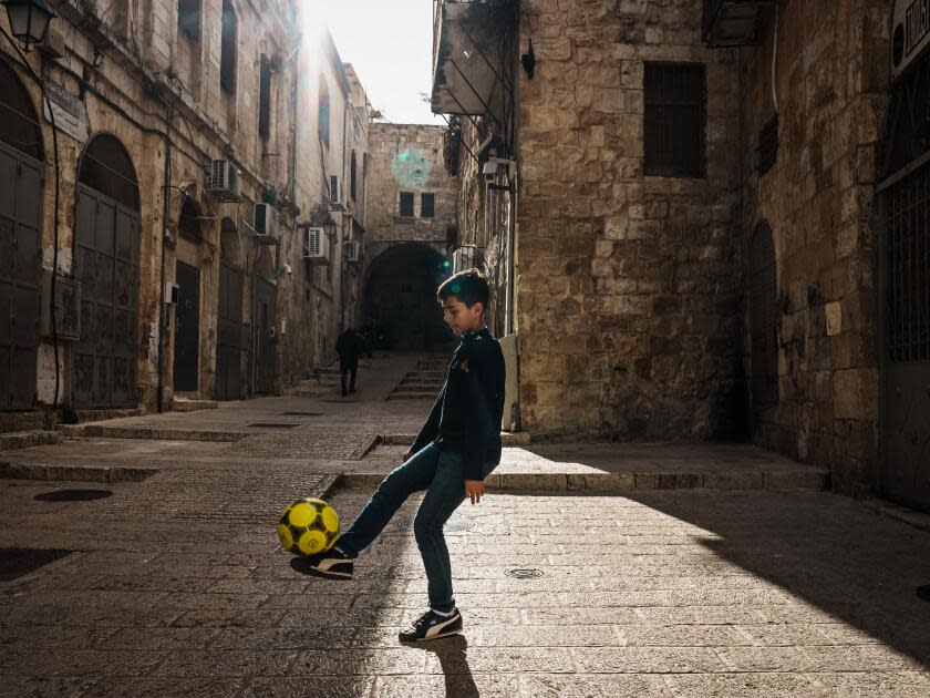 A young Palestinian boy plays with a soccer ball in the Muslim quarter inside the old city of Jerusalem