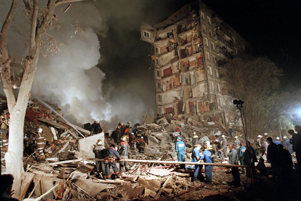 FILE - Smoke rises from an apartment building destroyed by a bomb blamed on Chechen militants, as Russian Emergency Situations Ministry officers and firefighters try to save people in Moscow, Russia, Thursday, Sept. 9, 1999. Dealing with Chechen separatists was an early test for Vladimir Putin, first as prime minister and then as president. (AP Photo/Ivan Sekretarev, File)