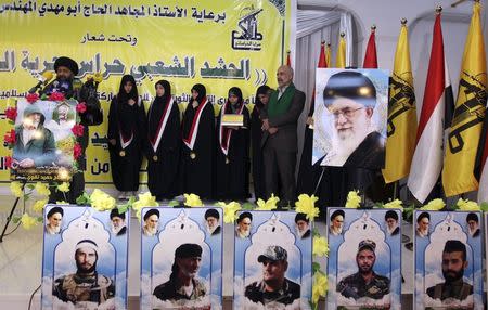 Family members of Iranian General Hamid Taghavi of Iraqi Shi'ite militia group Saraya al-Khorasani, attend a ceremony honouring him and other fighters of the group who died during their fight against the Islamic State, in Baghdad in this February 21, 2015 file photo. REUTERS/Ahmed Saad/Files