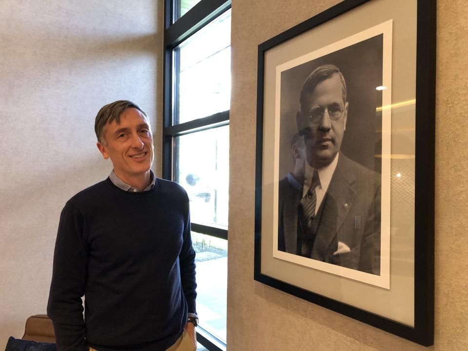 Jason Duckworth, president of Arcadia Land Development Co., stands by a photo of architect Oscar Martin, for whom The Martin at Doylestown apartment complex on North Main Street is named.