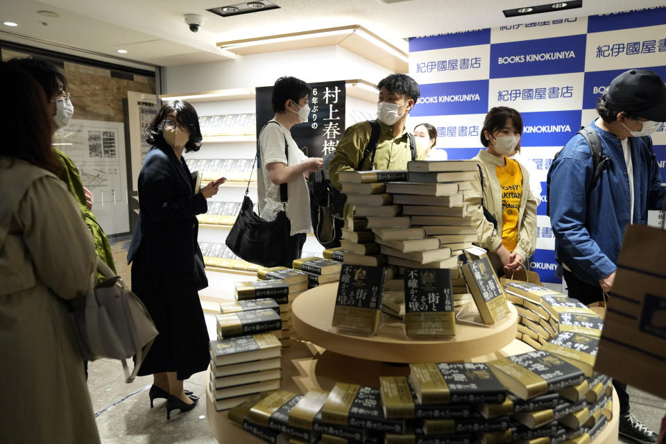 Customers line up to buy Japanese writer Haruki Murakami's new novel "The City and Its Uncertain Walls" on the first day for sale at Kinokuniya bookstore in Shinjuku district early Thursday, April 13, 2023, in Tokyo. Murakami wrote a story of a walled city when he was fresh off his debut. More than four decades later, as a seasoned and acclaimed novelist, he gave it a new life as “The City and Its Uncertain Walls.” (AP Photo/Mari Yamaguchi)