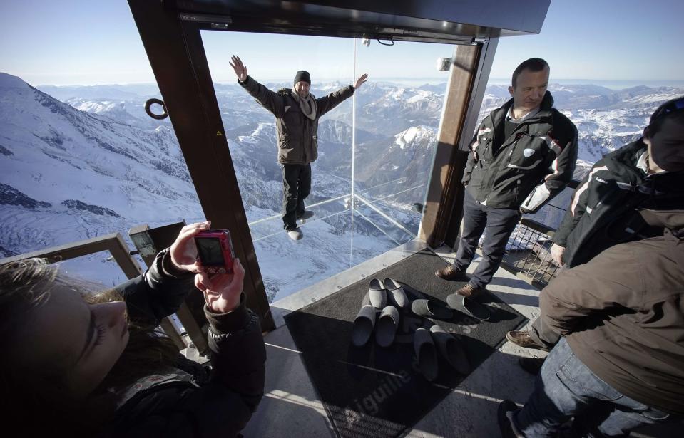 A visitor stands in the 'Step into the Void' installation as during a press visit at the Aiguille du Midi mountain peak above Chamonix, in the French Alps, December 17, 2013. REUTERS/Robert Pratta