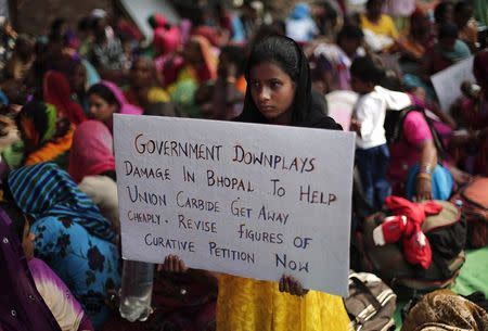 A child of a victim of the Bhopal gas tragedy, a gas leak from a Union Carbide pesticide plant that killed at least 3500 people, holds a placard during a sit-in protest in New Delhi November 10, 2014. REUTERS/Adnan Abidi