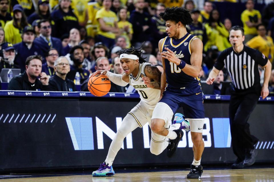 Michigan guard Dug McDaniel (0) dribbles against Toledo guard RayJ Dennis (10) during the second half of the first round of the NIT at Crisler Center in Ann Arbor on Tuesday, March 14, 2023.