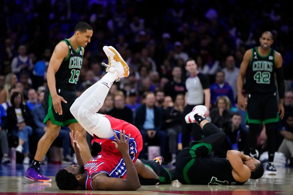 Grant Williams, front right, reacts after his face was driven into the floor after he was accidentally stepped on by Joel Embiid.