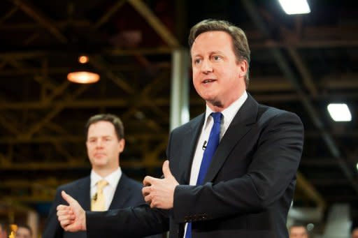 British Prime Minister David Cameron (right) speaks as British Deputy Prime Minister Nick Clegg listens during a visit to the CNH tractor plant in Basildon, Essex, last wee