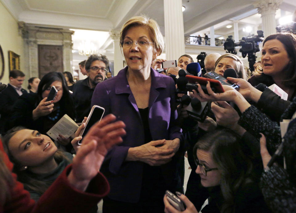 Sen. Elizabeth Warren, D-Mass., is surrounded by reporters at the Massachusetts Statehouse, Wednesday, Jan. 2, 2019, in Boston. Warren has taken the first major step toward launching a widely anticipated campaign for the presidency, hoping her reputation as a populist fighter can help her navigate a Democratic field that could include nearly two dozen candidates. (AP Photo/Elise Amendola)