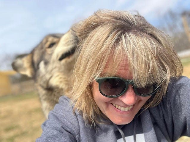 Bosco, another of the wolf dogs cared for by the Red Riding Hood Rescue Project, sniffs the hair of co-founder and president Susan Vogt.