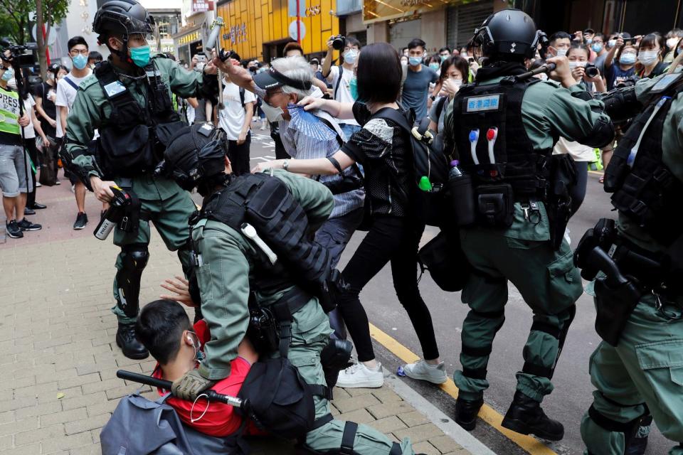 Demonstrators scuffle with riot police during a protest about new Hong Kong laws (REUTERS)