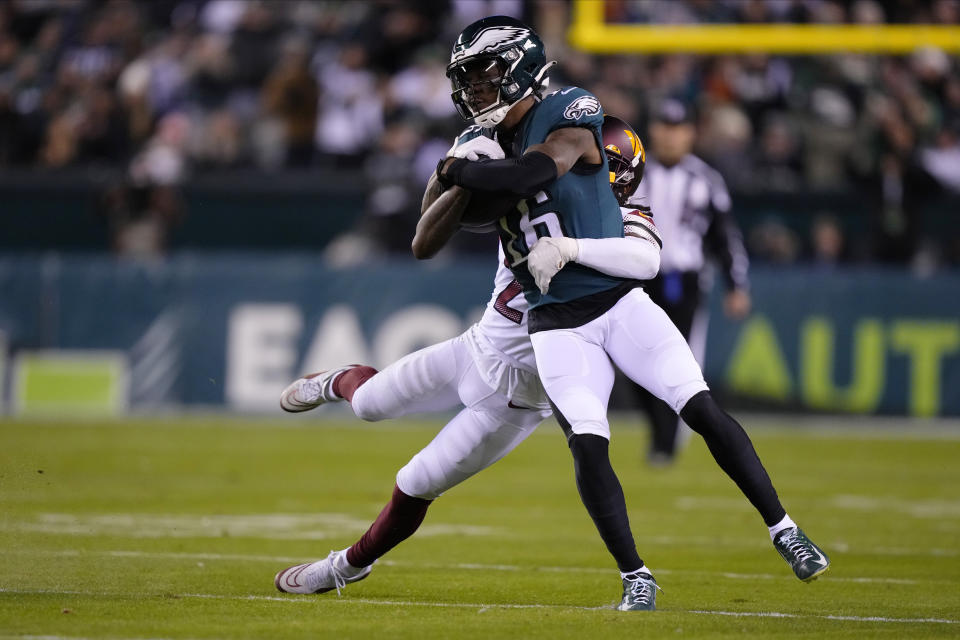 Philadelphia Eagles wide receiver Quez Watkins (16) is tackled by Washington Commanders safety Bobby McCain (20) during the second half of an NFL football game, Monday, Nov. 14, 2022, in Philadelphia. (AP Photo/Matt Rourke)